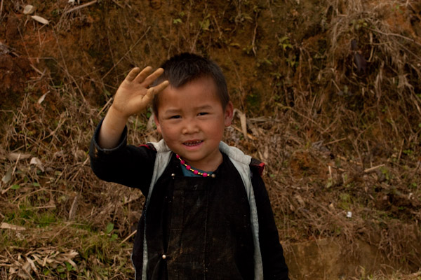 Black Hmong boy waving "hi"